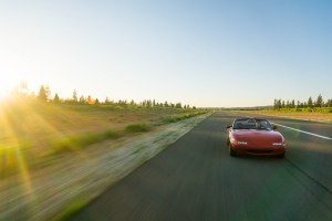 Une Mazda MX-5 sur la route sous un couché de soleil